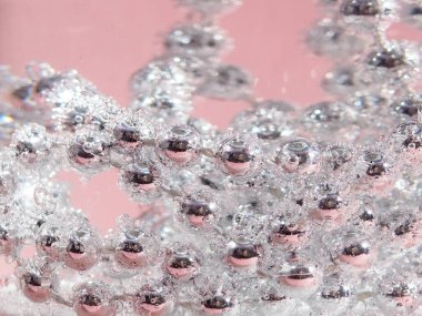 Şarap kadehinde su, baloncuk, makro, fotoğraf ve tasarım için arka planda gümüş boncuklar var.