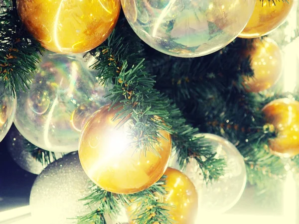 Közelkép Bauble akasztás Megvilágított karácsonyfa. Karácsonyi labdák és csecsebecsék, mint a háttér képeslapok, sok különböző karácsonyi játékok fények nélkül fókusz, közelkép — Stock Fotó