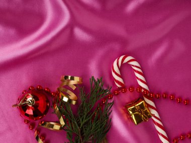 Güzel bir Noel arkaplanı, parlak topları ve pembe kurdeleleri var. Düz yerde, üst tarafta. Hediyeli Noel kompozisyonu ve pembe arka planda bir Noel ağacı..
