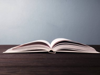 Mavi arkaplan üzerine açık bir kitap, yeni bilgi kavramı olarak açık sayfalar, çevrimiçi kişisel çalışma.