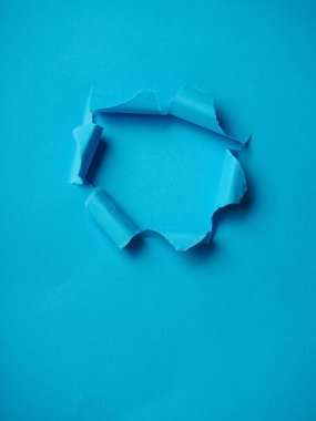 Mavi arkaplan ile yırtılmış Kağıt Deliği.