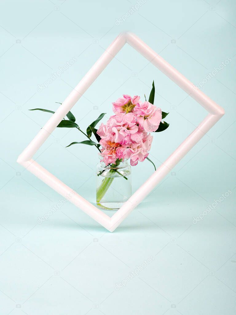 White landscape frame mockup with flowers in styled vase near blue wall. Empty frame mock up for presentation design. Template framing for modern art