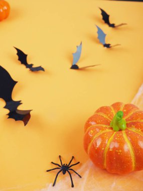 Cadılar Bayramı balkabakları ve yarasalar turuncu arka planda. Cadılar Bayramı bestede yatıyordu..