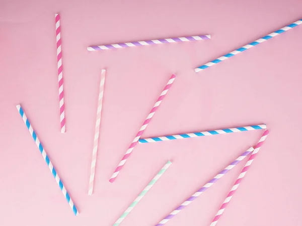Drinking paper straws for cocktails on pink background. Paper disposable eco-friendly straws.