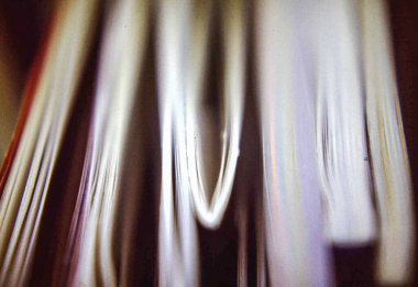 Close-up of stacked magazines with layered paper edges and graphic detail in soft ambient light and editorial context