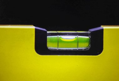 Yeşil sıvıyla merkezlenmiş, siyah kesimli sarı ev çerçeveli, teknik ve sembolik temalar için sahnelenmiş ruh seviyesindeki baloncukların makro görünümü