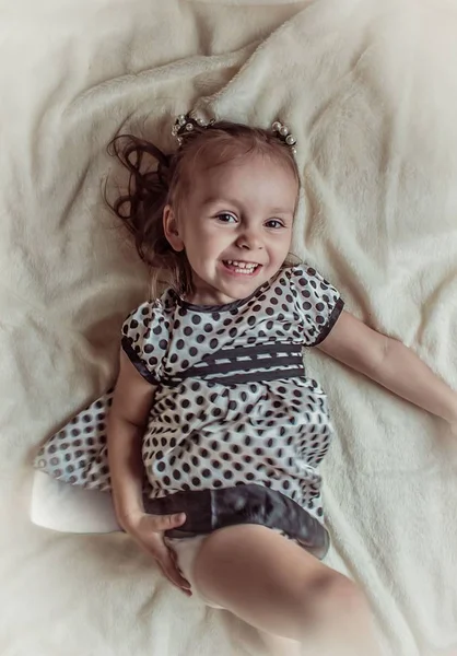 Kleines Mädchen Lächelnd Auf Dem Bett Liegend — Stockfoto