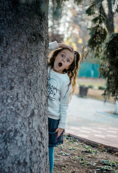 Mädchen Guckt Überrascht Hinter Einem Baum Hervor — Stockfoto