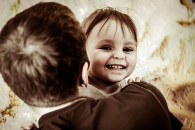 Babam bebekle yatakta oynuyor.