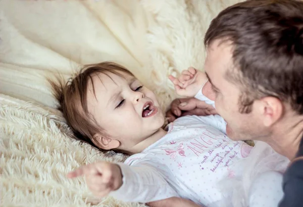 Papa Spielt Mit Dem Baby Bett lizenzfreie Stockbilder