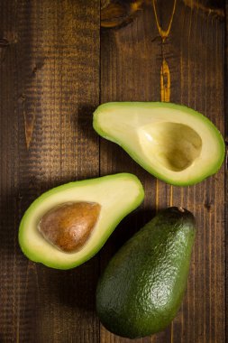 Koyu ahşap arka plan üzerinde avokado. Sağlıklı gıda kavramı.