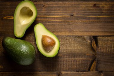Koyu ahşap arka plan üzerinde avokado. Sağlıklı gıda kavramı.