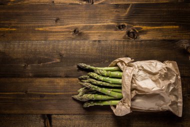 Kağıt torba içinde taze yeşil kuşkonmaz demet. Kopya alanı.