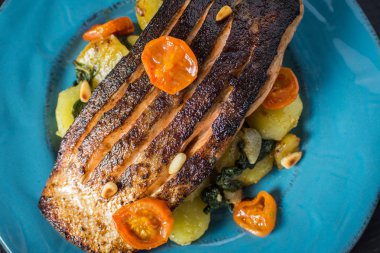 Mavi plaka üzerinde sebze ile taze ızgara somon. Sağlıklı yemek kavramı.