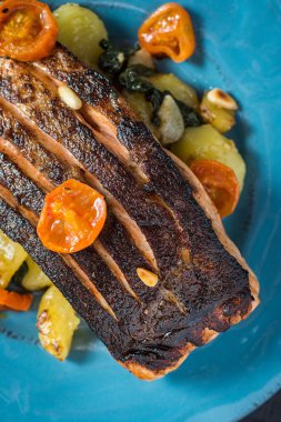 Mavi plaka üzerinde sebze ile taze ızgara somon. Sağlıklı yemek kavramı.