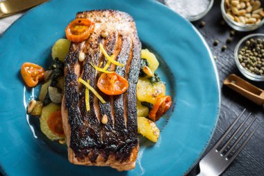 Mavi plaka üzerinde sebze ile taze ızgara somon. Sağlıklı yemek kavramı.