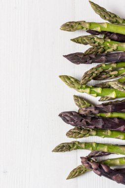 Taze kuşkonmaz çeşitleri Beyaz ahşap zemin üzerinde. Kopya alanı.