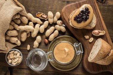 Fıstık ezmesi ve jöle sandviç rustik ahşap zemin üzerinde. Ev yapımı sağlıklı kahvaltı.