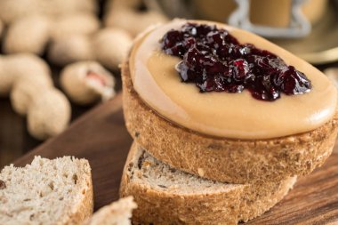 Fıstık ezmesi ve jöle sandviç rustik ahşap zemin üzerinde. Ev yapımı sağlıklı kahvaltı.