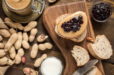 Fıstık ezmesi ve jöle sandviç rustik ahşap zemin üzerinde. Ev yapımı sağlıklı kahvaltı.