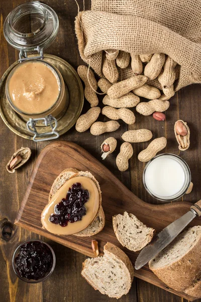 Peanut Butter and Jelly Sandwich on Rustic Wooden Background. Homemade Healthy Breakfast.