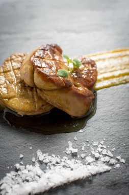 Kızarmış kaz ciğeri ile Mango püresi karanlık taş zemin üzerine. Ördek 