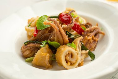 Taze kızarmış Squids, biber ve nane yaprakları beyaz plaka üzerinde