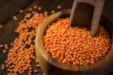 Kase koyu ahşap masa üzerinde sağlıklı organik kırmızı mercimek