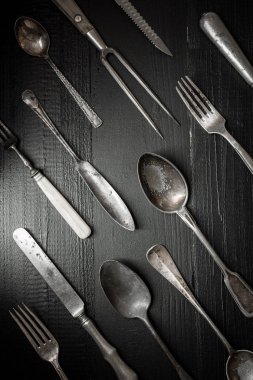 Eski rustik çatal bıçak takımı koyu ahşap zemin üzerinde. Mutfak ve gıda kavramı.