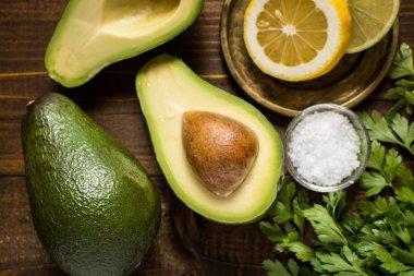 Koyu ahşap zemin üzerine taze avokado. Sağlıklı gıda kavramı.