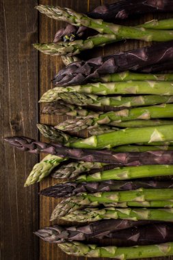 Koyu ahşap arka plan üzerinde kuşkonmaz çeşitleri