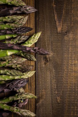 Koyu ahşap arka plan üzerinde kuşkonmaz çeşitleri