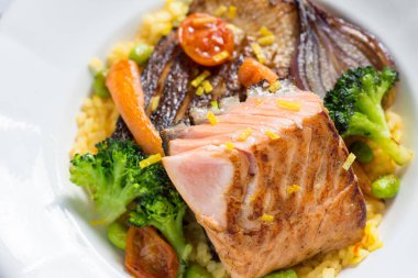 Beyaz tabakta sebzeli ızgara somon fileto