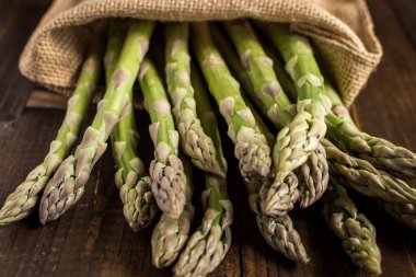 Juta çanta beyaz tahta masada yeşil kuşkonmaz