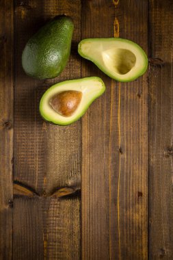 Koyu ahşap zemin üzerine taze avokado. Sağlıklı gıda kavramı.