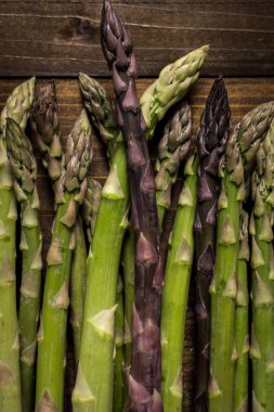 Koyu ahşap arka plan üzerinde kuşkonmaz çeşitleri