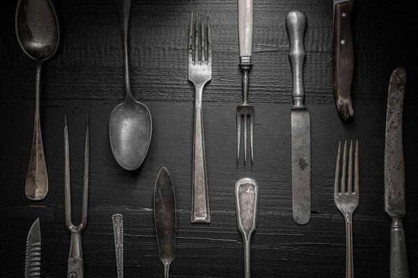 Rustic Silverware on Dark Wooden Background. Kitchen and Restaurant Concept.
