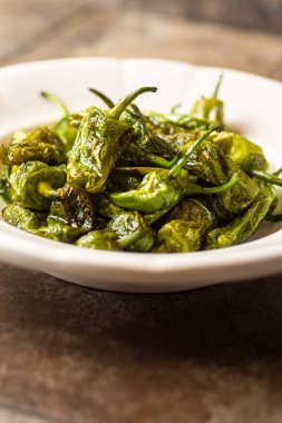 Rustik beyaz tabak içinde ızgara Padron biber. Gizemli de Padro