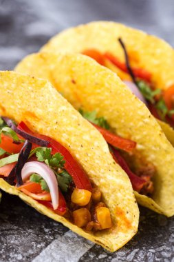 Üç renkli Meksika Tacos taş zemin üzerine kabuklarında