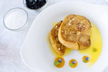 Beyaz plaka üzerinde elma soslu kızarmış kaz ciğeri. Kaz ciğeri Fin