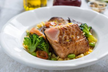 Beyaz tabakta sebzeli ızgara somon fileto