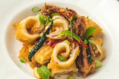 Fried Squids kalamar, biber ve nane yaprakları beyaz plaka üzerinde