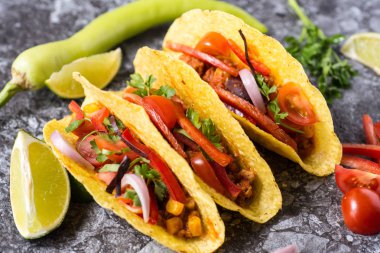 Üç renkli Meksika Tacos taş zemin üzerine kabuklarında