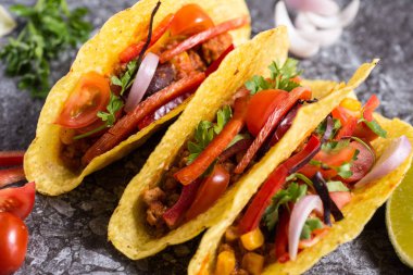 Üç renkli Meksika Tacos taş zemin üzerine kabuklarında