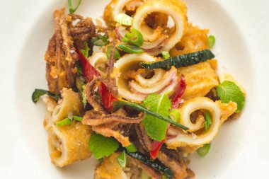 Fried Squids kalamar, biber ve nane yaprakları beyaz plaka üzerinde