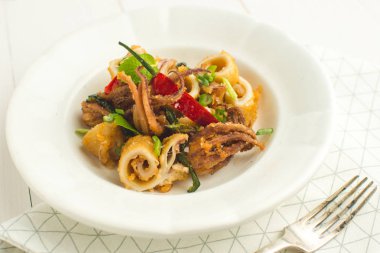 Fried Squids kalamar, biber ve nane yaprakları beyaz plaka üzerinde