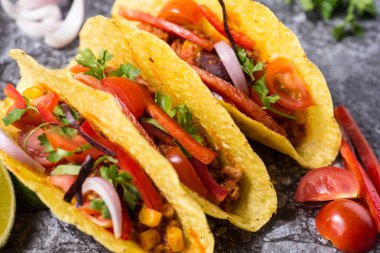 Üç renkli Meksika Tacos taş zemin üzerine kabuklarında