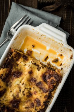 Koyu ahşap arka plan üzerinde çatal ile İtalyan lazanya yemek