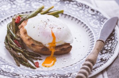 Haşlanmış yumurta, yeşil kuşkonmaz ve pul biber ile ekmek. Sağlıklı kahvaltı konsepti.