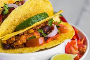 Kabuklarında gri arka plan üzerinde renkli Meksika Tacos